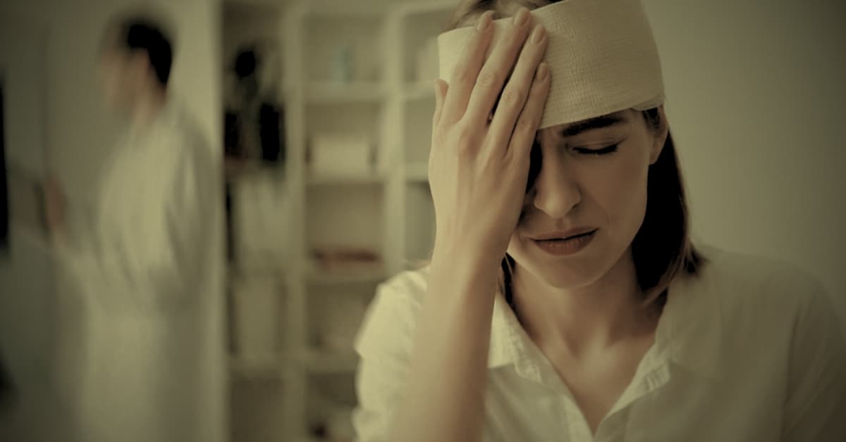 Woman with head bandage after traumatic brain injury seeking legal help