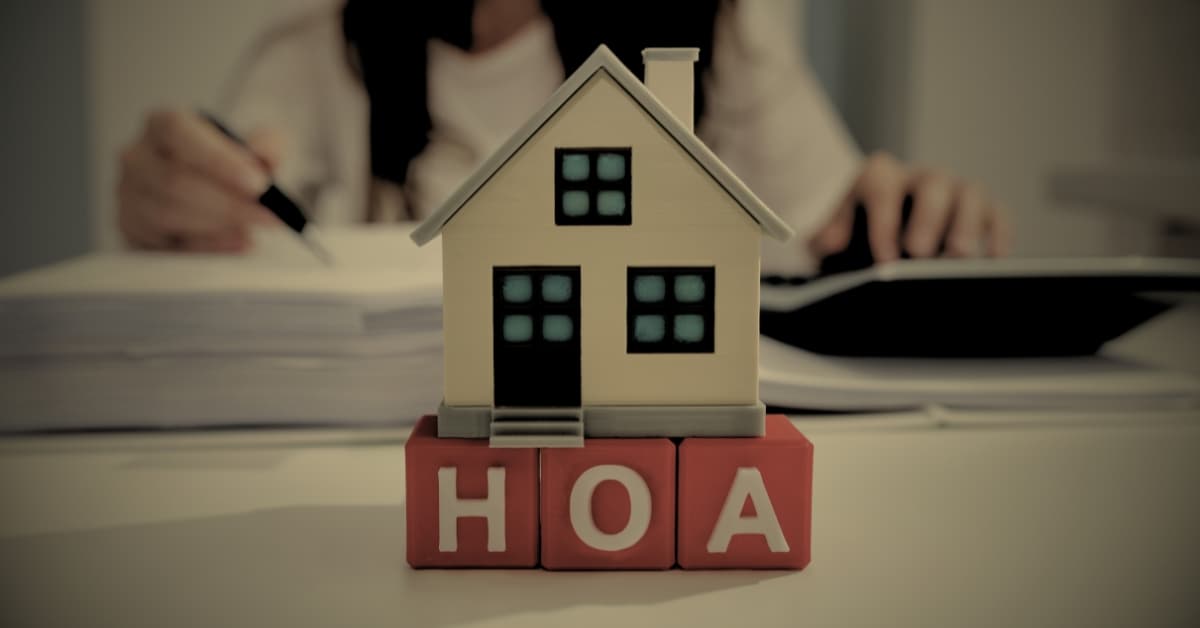 HOA fees in Florida — house model on HOA blocks with homeowner reviewing documents