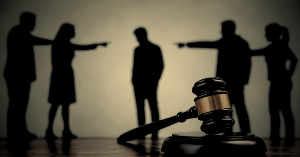 Defamation of character Florida — silhouettes pointing fingers with gavel representing false accusations