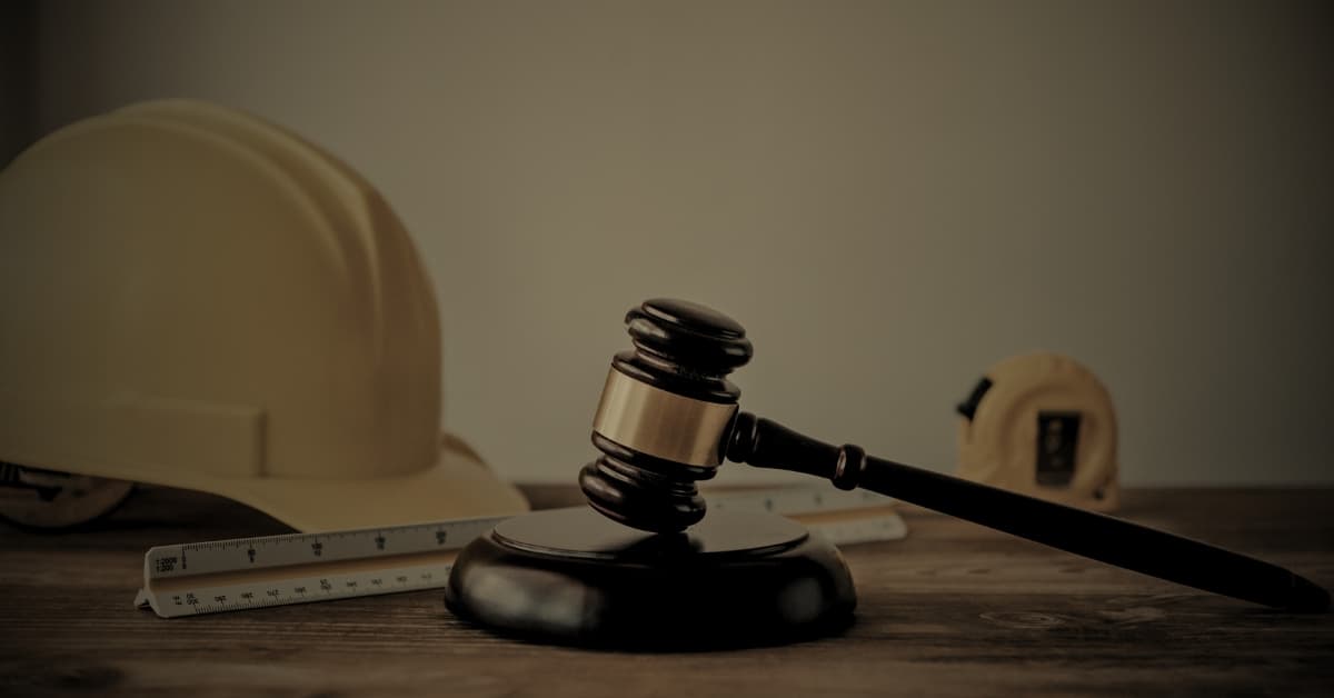 Construction lien Florida, judge's gavel with hard hat and measuring tape on wooden desk
